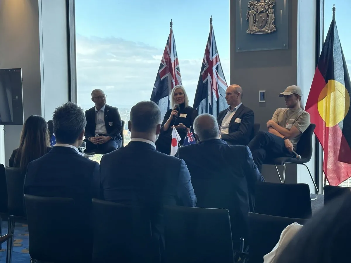 Kirsten on a panel at the Japanese Embassy in Australia, with Australian and Japanese flags visible